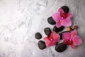 Spa stones and pink orchid flowers on white marble background. top view Royalty Free Stock Photo