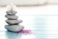 Spa stones, sea salt and flower on table against blurred background. Royalty Free Stock Photo