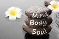 Spa stones with words Mind, Body, Soul and plumeria flowers in water. Zen lifestyle Royalty Free Stock Photo