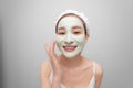 Spa teen Asian girl applying facial clay mask. Beauty treatments. Over white background Royalty Free Stock Photo