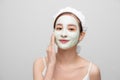 Spa teen Asian girl applying facial clay mask. Beauty treatments. Over white background Royalty Free Stock Photo