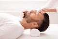Spa therapist making relaxing massage for handsome middle-aged man Royalty Free Stock Photo