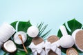 Spa tools: white towel, bamboo slippers, herbal ball, cream, wooden brush, coconut oil, monstera on blue background. Cosmetic Royalty Free Stock Photo