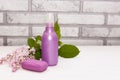 Spa towels and soap and lilac flowers on a white wooden table