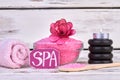 Spa treatment concept. Pink salt with rolled towel and stones. Royalty Free Stock Photo