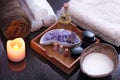 A spa treatment set with purple salt, hot aromatic oil and soft towels. Close coconut with milk.