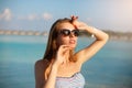 Spa wellness beach beauty woman in bikini swimwear relaxing and sun bathing near blue lagoon. Beautiful peaceful young Royalty Free Stock Photo