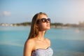 Spa wellness beach beauty woman in bikini swimwear relaxing and sun bathing near blue lagoon. Beautiful peaceful young Royalty Free Stock Photo