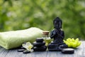 Spa and wellness composition with statuette of Buddha, oil bottle and zen stones