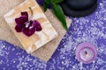 Spa Wellness Concept. Natural Loofah Sponge, Almond Goat milk Soap, Basalt Stones, Bamboo, Orchid and Lavender Tea Light Candle Royalty Free Stock Photo