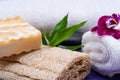 Spa Wellness Concept. Natural Loofah Sponge, Almond Goat`s milk Soap, White Towels, Basalt Stones, Bamboo and Orchid Flower Royalty Free Stock Photo