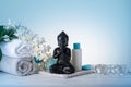 Spa or wellness decoration with statue of Buddha and burning candles on gradient turquoise background