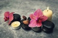 Spa and wellness. orchid flowers with massage stones and candles on rock background Royalty Free Stock Photo