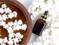 Spa and wellness with perfumed white lilac flowers water in wooden bowl and terry towel and bottle aromatherapy, top view, flat Royalty Free Stock Photo