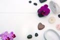 Spa setting with pink orchids, black stones and bath salts on wood background. Royalty Free Stock Photo