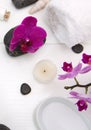 Spa setting with pink orchids, black stones and bath salts on white wood . Royalty Free Stock Photo