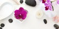 Spa setting with pink orchids, black stones and bath salts on wood background. Royalty Free Stock Photo