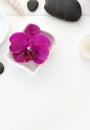 Spa setting with pink orchids, black stones and bath salts on wood background. Royalty Free Stock Photo