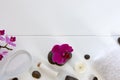 Spa setting with pink orchids, black stones and bath salts on white wood background. Royalty Free Stock Photo