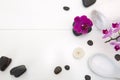 Spa setting with pink orchids , black stones and candle on white background.