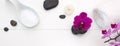 Spa setting with pink orchids , black stones and candle on white wood background. Royalty Free Stock Photo