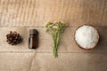 Spa and wellness setting with sea salt, oil essence, cones and candle on wooden background. Fall autumn wellness concept, Relax