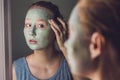 Spa Woman applying Facial green clay Mask. Beauty Treatments. Close-up portrait of beautiful girl applying facial mask Royalty Free Stock Photo