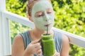 Spa Woman applying Facial green clay Mask. Beauty Treatments. Fresh green smoothie with banana and spinach with heart of Royalty Free Stock Photo