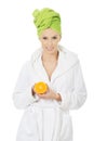 Spa woman in bathrobe holding orange. Royalty Free Stock Photo