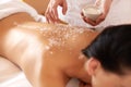 Spa Woman. Brunette Getting a Salt Scrub Beauty Treatment in the Royalty Free Stock Photo
