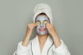 Spa woman with cucumber slices and moisturizing cosmetic face mask on her face. Facial treatment and skin care concept