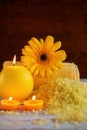 Spa yellow products setting. Sea salt ,towel and candles on dark wooden background Royalty Free Stock Photo