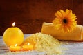 Spa yellow products setting. Sea salt ,towel and candles on dark wooden background Royalty Free Stock Photo