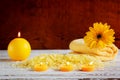 Spa yellow products setting. Sea salt ,towel and candles on dark wooden background Royalty Free Stock Photo