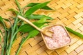 Spa, zen, massage concept. Pink himalayan bath salt with spoon, bamboo leaves, soap dish Royalty Free Stock Photo