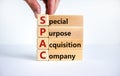 SPAC, special purpose acquisition company symbol. Businessman holds cubes with words `SPAC` on beautiful white background, copy