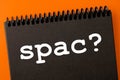Spac special purpose acquisition company theme. spak? inscription in an open black notebook, on an orange background Royalty Free Stock Photo