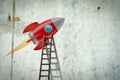 Space rocket on a concrete wall. Ladder to her. Concept of a new project. Royalty Free Stock Photo