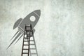 Space rocket on a concrete wall. Ladder to her. Copy space. Concept of a new project Royalty Free Stock Photo