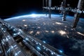 Space station orbiting Earth with city lights below Royalty Free Stock Photo