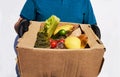 Man in black gloves hold food in a donation cardboard box, isolated on white background