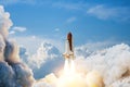 Spaceship lift off. Space shuttle with smoke and blast takes off into space on a background of blue sky.