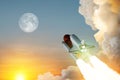Spaceship lift off. Space shuttle with smoke and blast takes off into space on a background of sunset with a full moon.