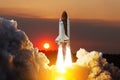Spaceship lift off. Space shuttle with smoke and blast takes off into space on a background of sunset.