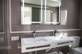 Spacious bathroom in gray tones with heated floors, walk-in shower, double sink vanity and skylights