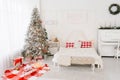 Spacious bright loft-style bedroom in white and red colors with a decorated Christmas tree Royalty Free Stock Photo