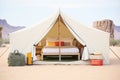 spacious canvas tent with a bed inside, desert backdrop Royalty Free Stock Photo