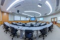 A spacious conference room filled with numerous tables and chairs, providing ample space for meetings and presentations, A Royalty Free Stock Photo