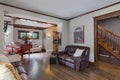 Spacious cream living room with leather sofas and a piano in the background