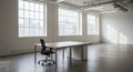 Spacious empty office with a single desk and black swivel chair. Large windows span Royalty Free Stock Photo